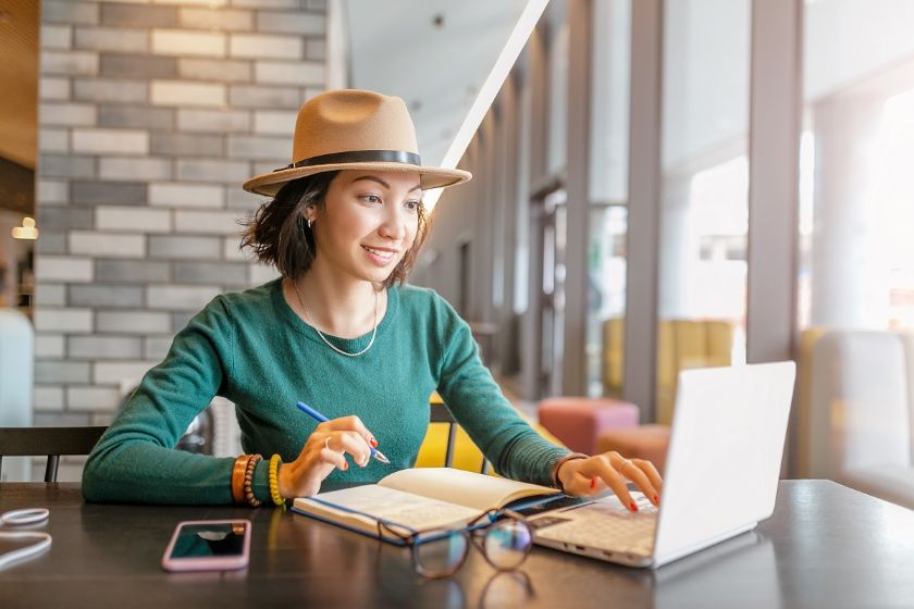 A woman on her computer researching how to pay off her credit card debt