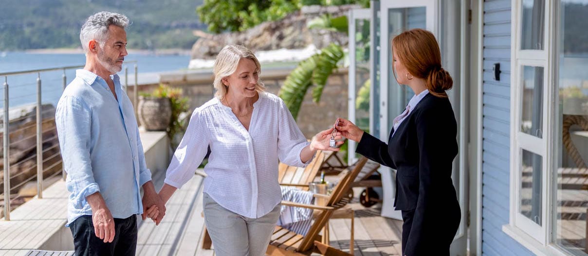 An officer handing over home keys to a happy couple.