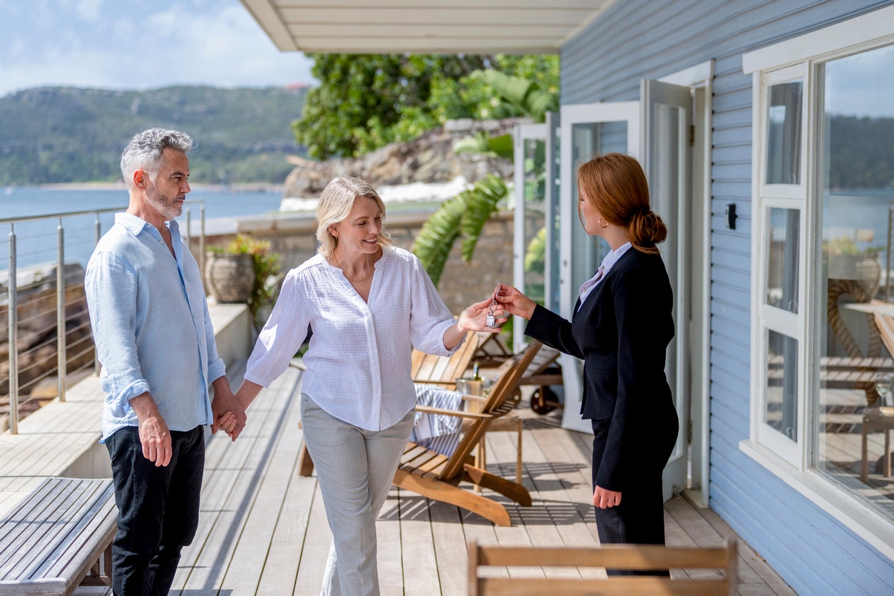 An officer handing over home keys to a happy couple.