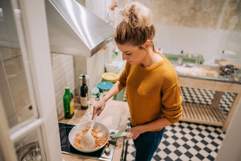 A person cooks in her kitchen