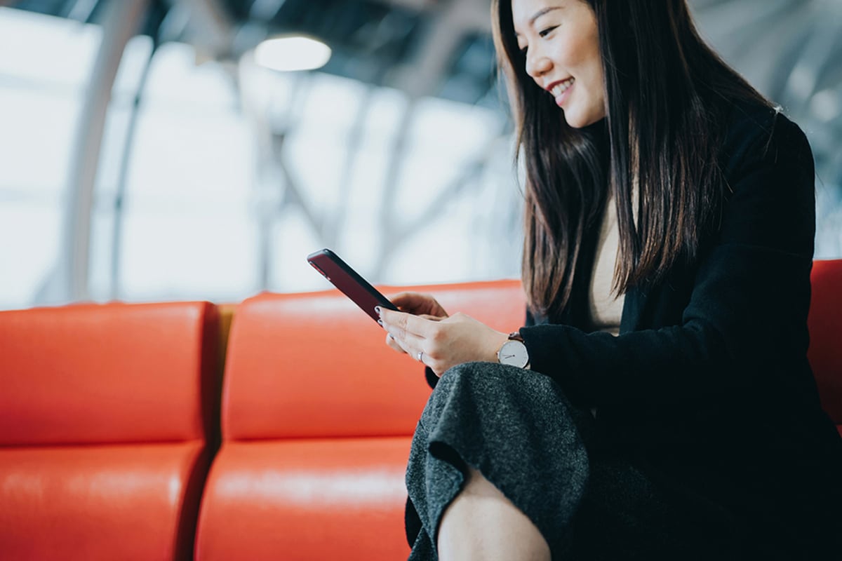 A person using a mobile phone at the airport.