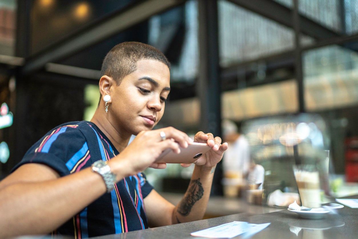 Woman is taking a picture of a check that lays on the counter in the coffee shop