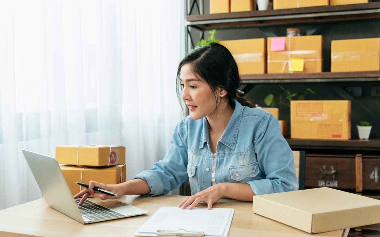 A professional image of a person sitting at a desk, reviewing their savings account balance on a laptop.