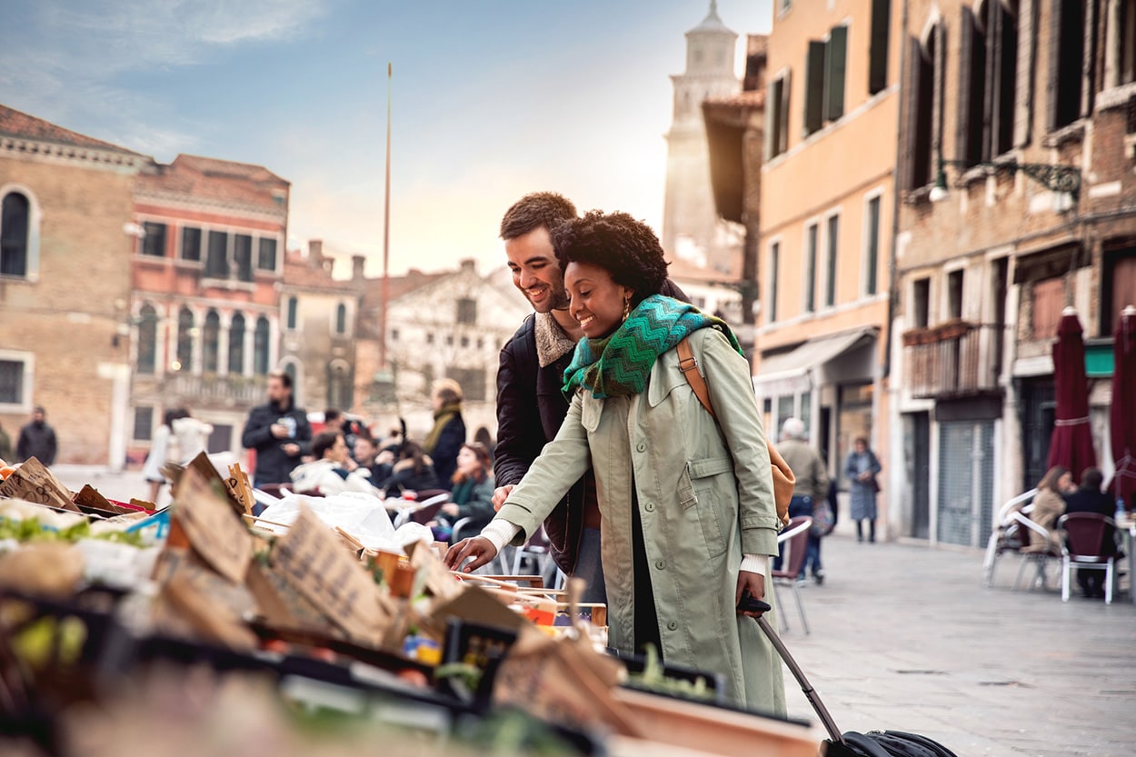 couple looking at something at an outdoor market in a city