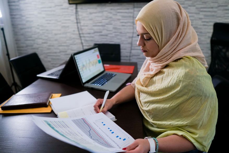 Woman working on charts and graphs at her desk