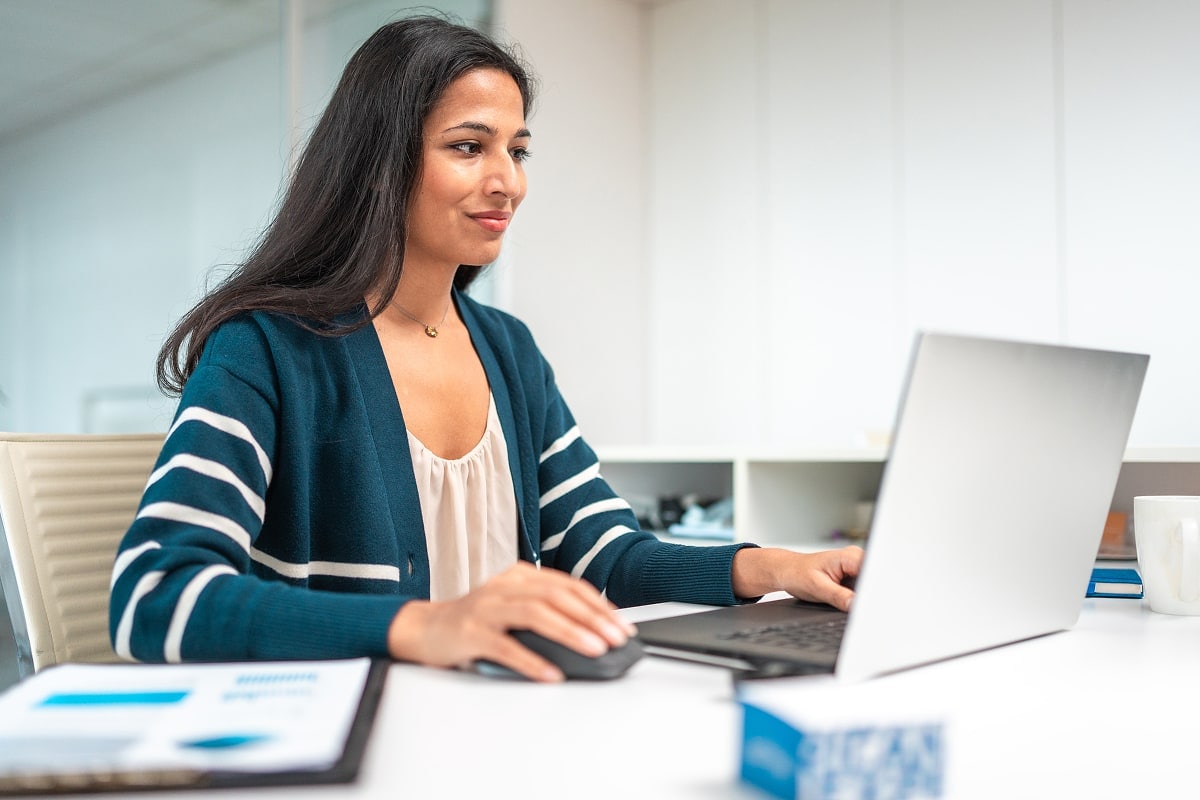 A professional image of a person reviewing their credit report on a laptop, with a side-by-side comparison of installment and revolving credit.