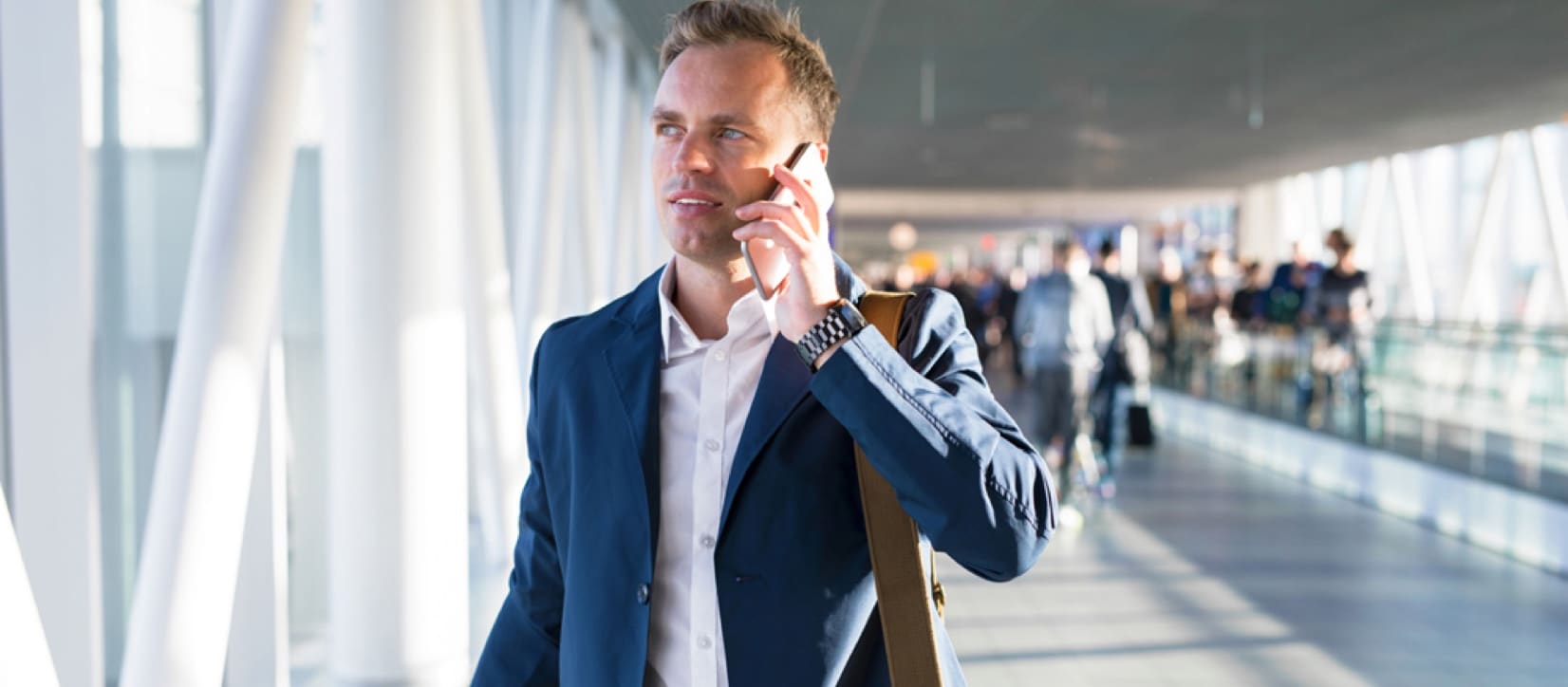 Man on phone walking through a busy airport