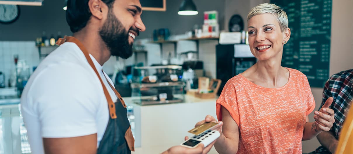 A person using a card to make a purchase in a shop