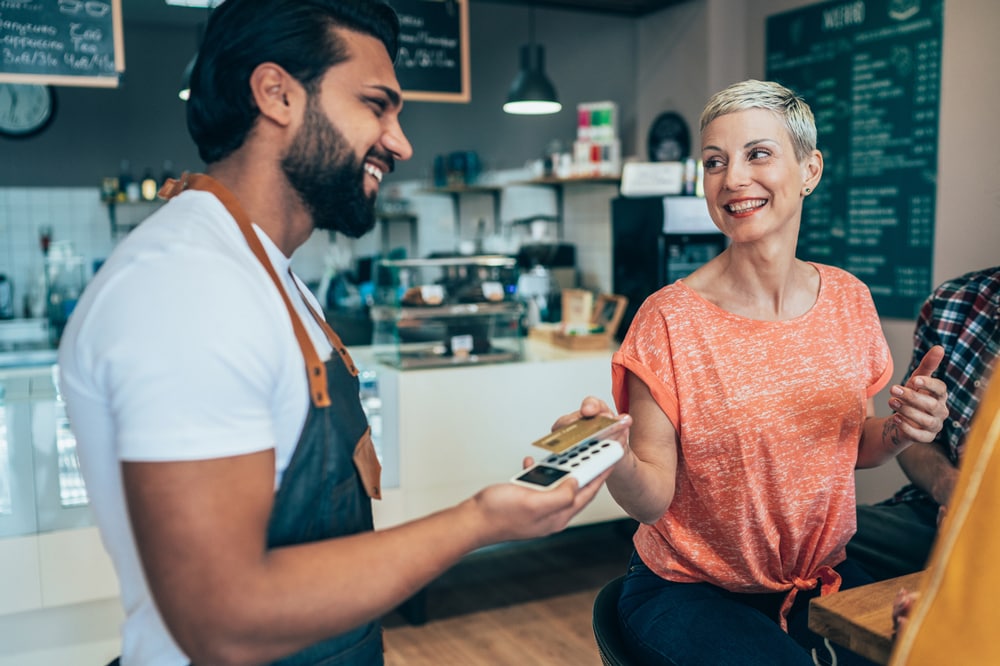 A person using a card to make a purchase in a shop
