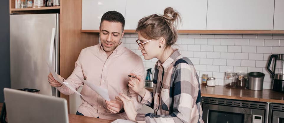 A man and woman reviewing documents to understand the differences between money market and savings accounts.