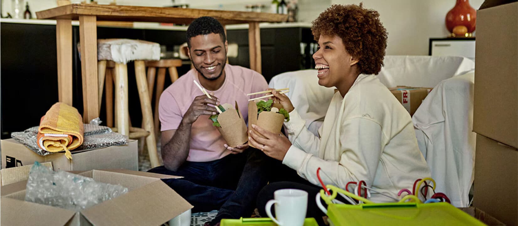 A couple takes a break from unpacking to enjoy on the floor of their new home