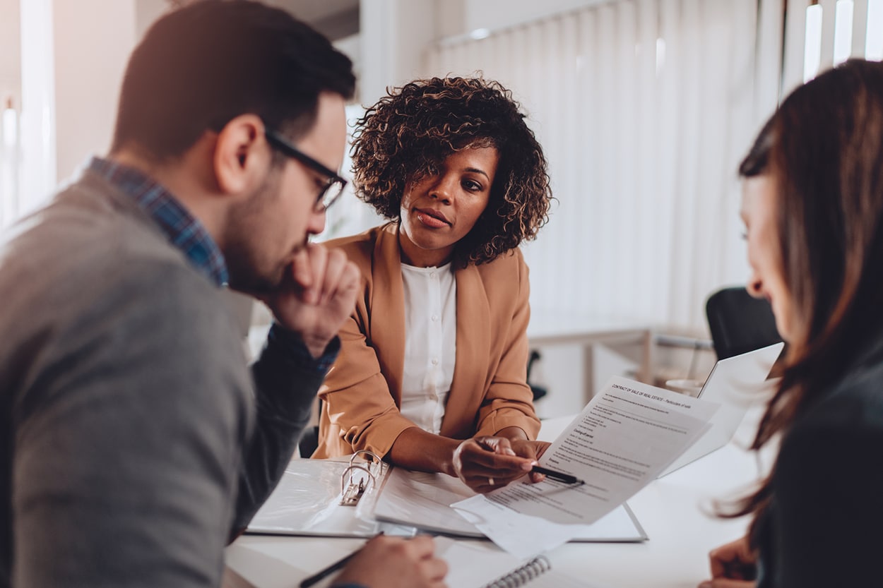 A man and two women engage in a discussion during a meeting about new rules for inherited IRAs and 401(k)s.
