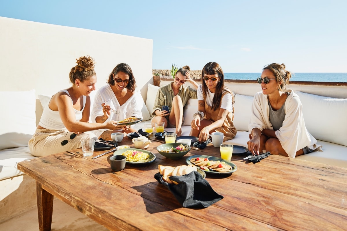 Someone enjoying time in a restaurant with outdoor seating overlooking the beach
