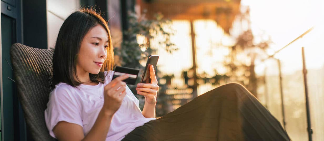 A person holding a credit card is researching whether she can pay off the credit card early