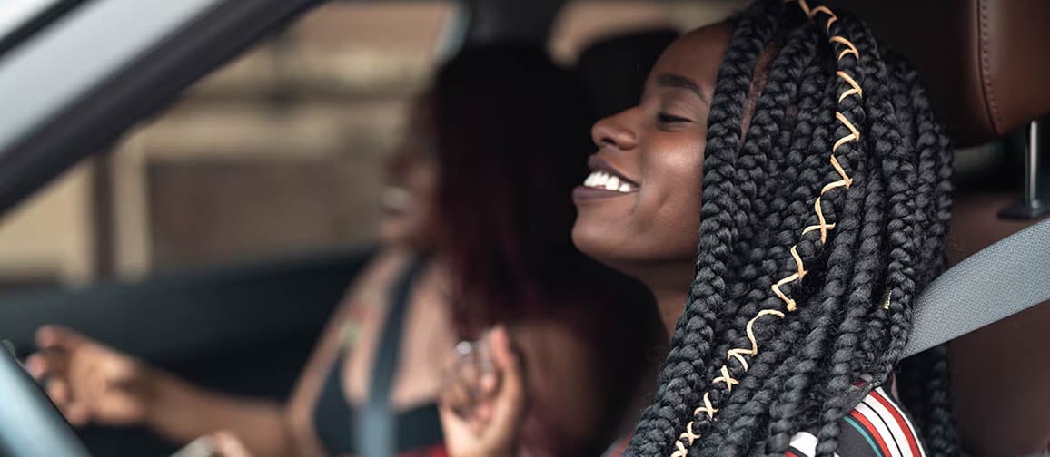 A happy driver behind the wheel with a co-passenger
