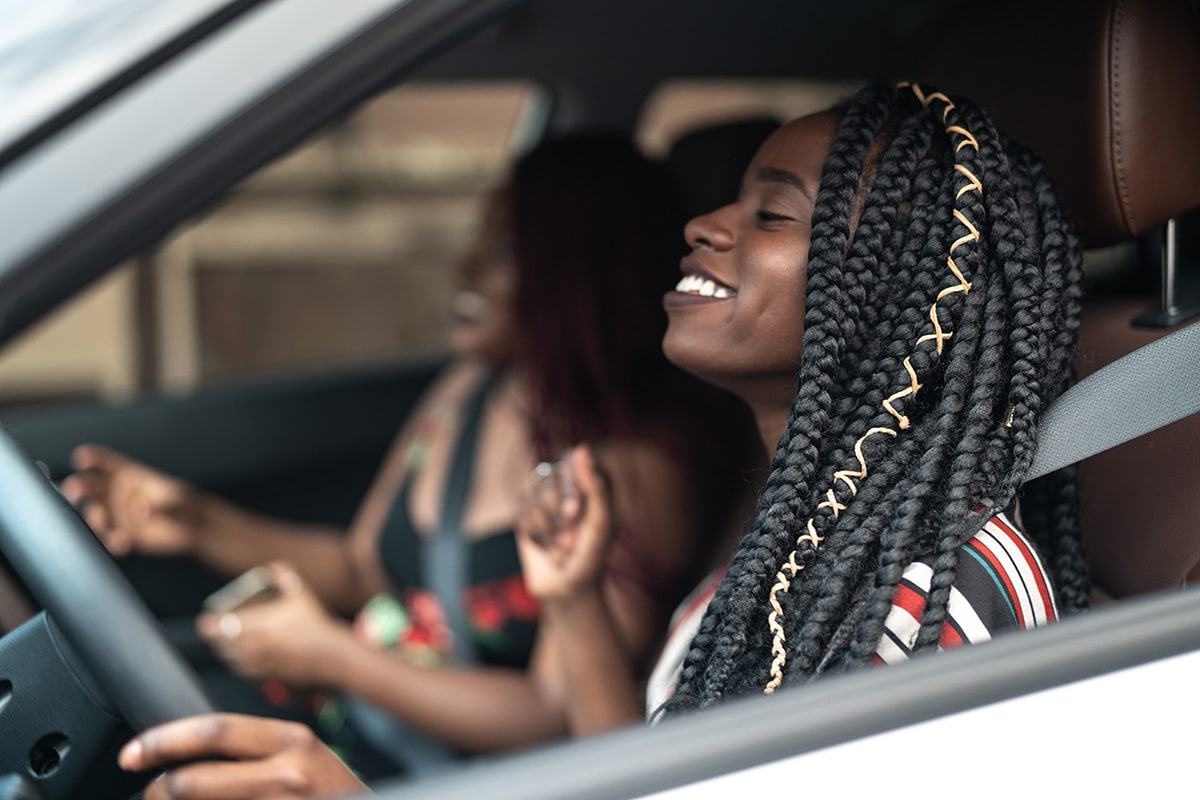 A happy driver behind the wheel with a co-passenger