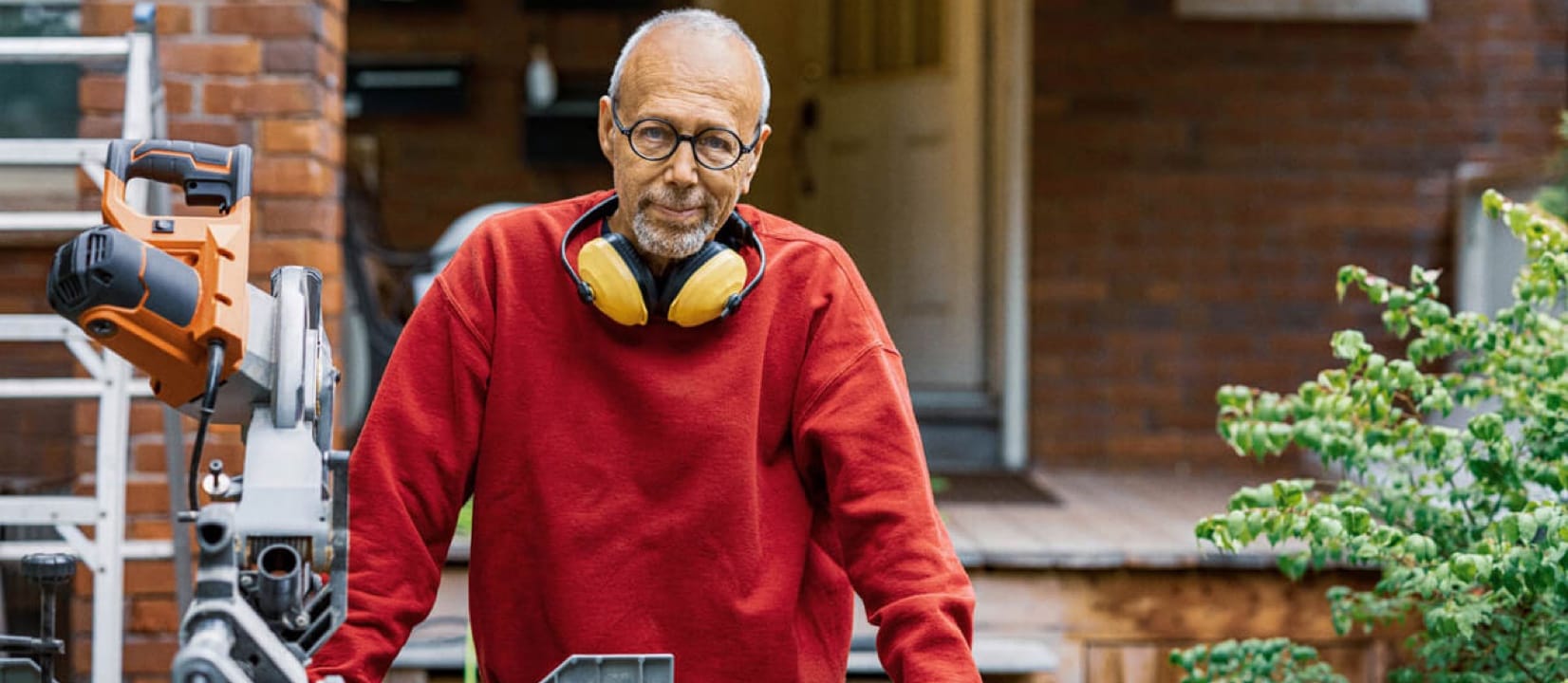 A man standing with equipments on the front porch.