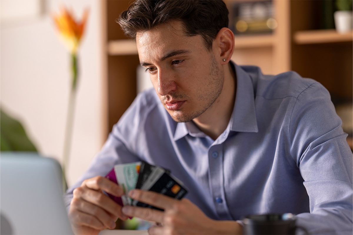 A young person holding multiple cards in their hand as though considering them.