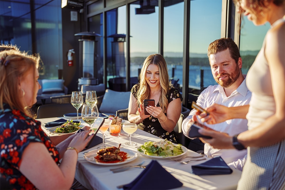 Someone using their phone to send money while out to dinner with friends