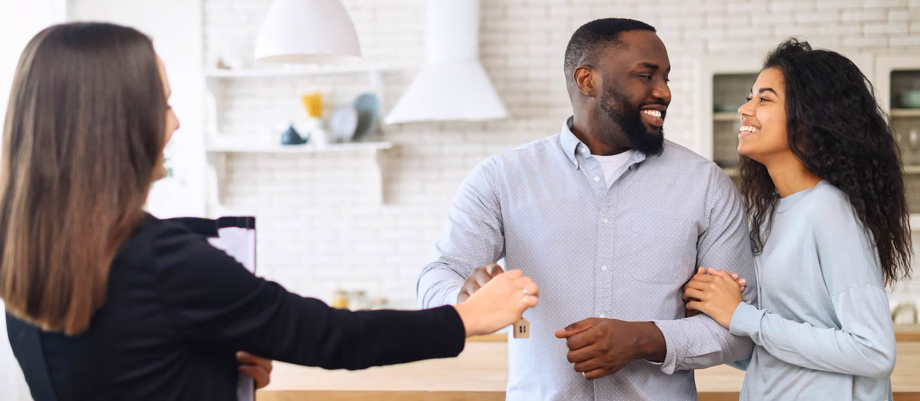 A couple holding new home keys, looking happy