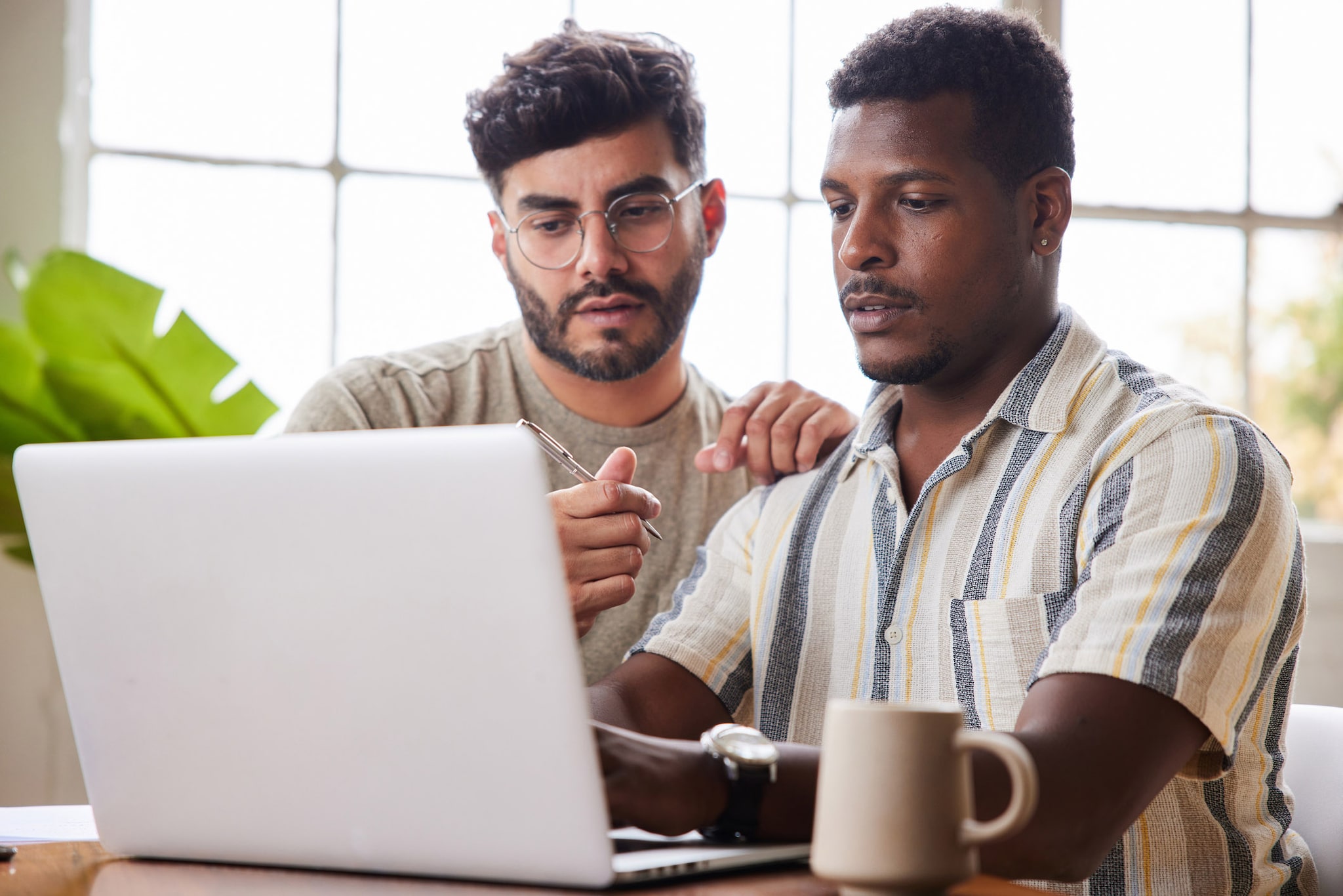Two men looking at a laptop