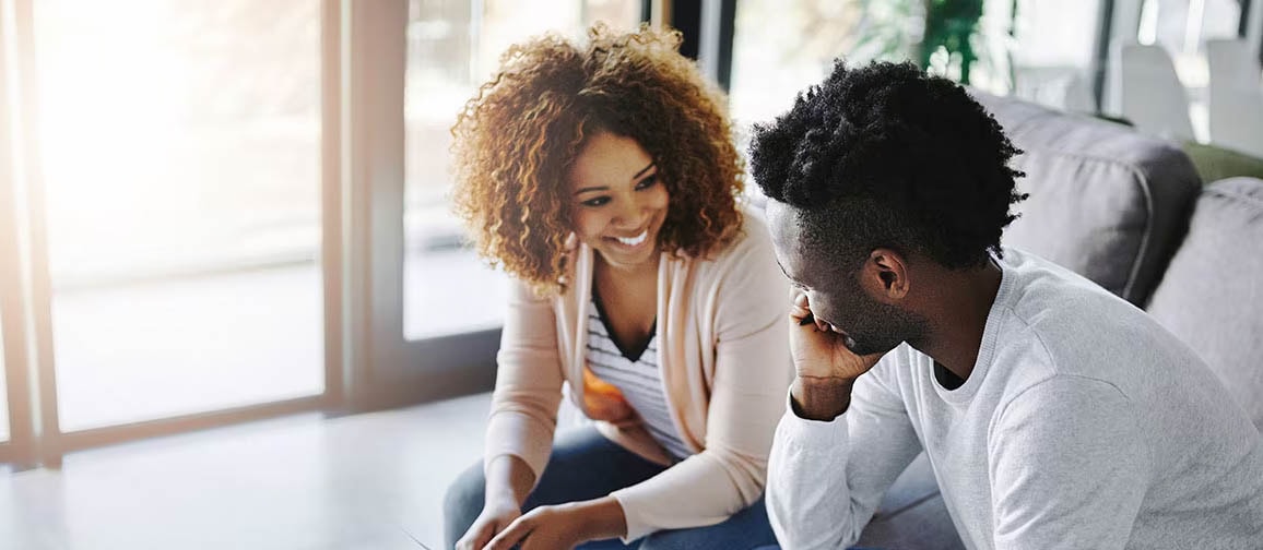A photo of a couple signing documents together, potentially including a subordination agreement.