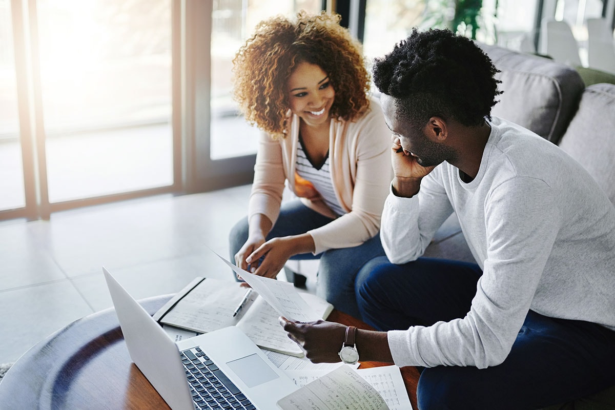 A photo of a couple signing documents together, potentially including a subordination agreement.