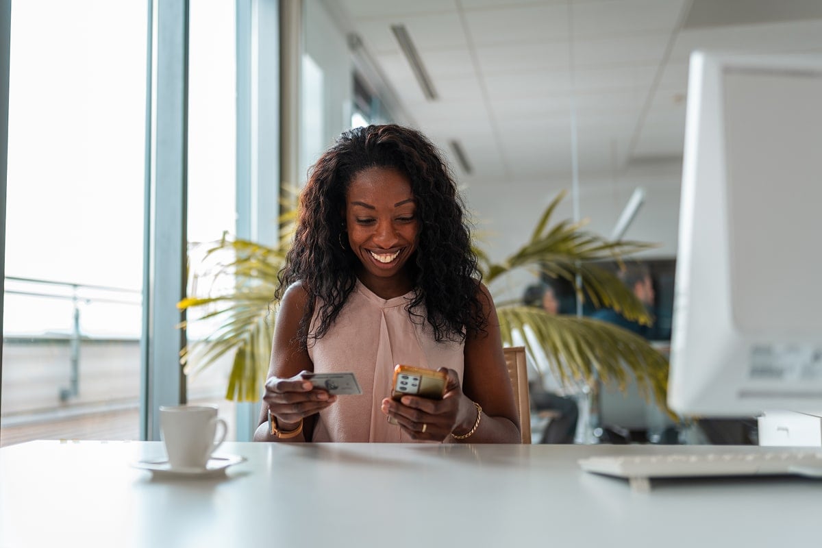 A professional image of a person using a mobile banking app on their smartphone.