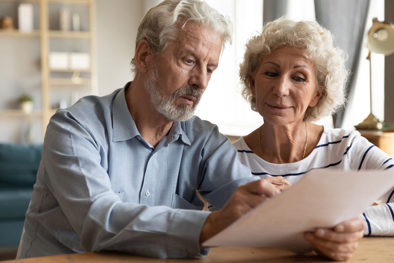 Older man and woman checking their credit card debts