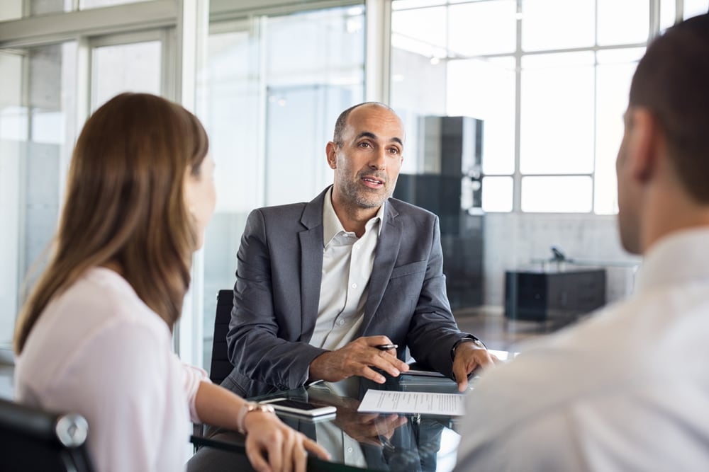Two men and a woman are sitting in the office and talking