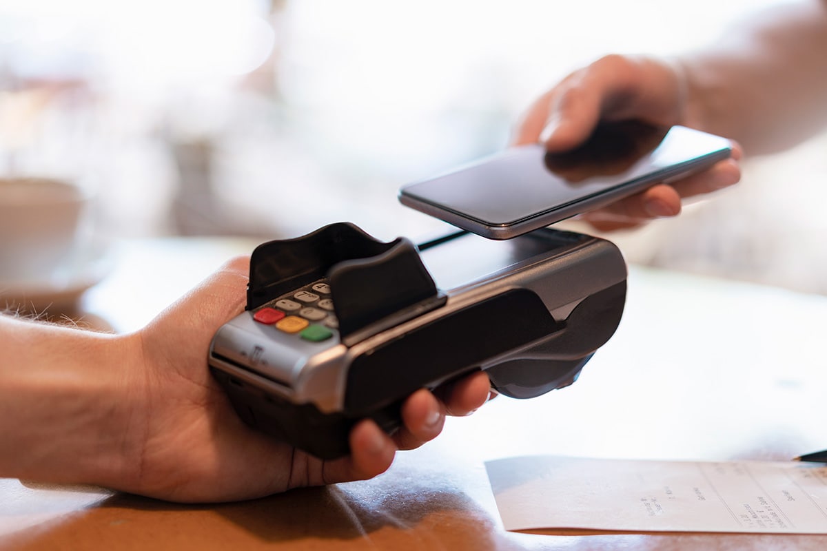 A person holds a smartphone and a credit card, illustrating the concept of a digital wallet for secure transactions.