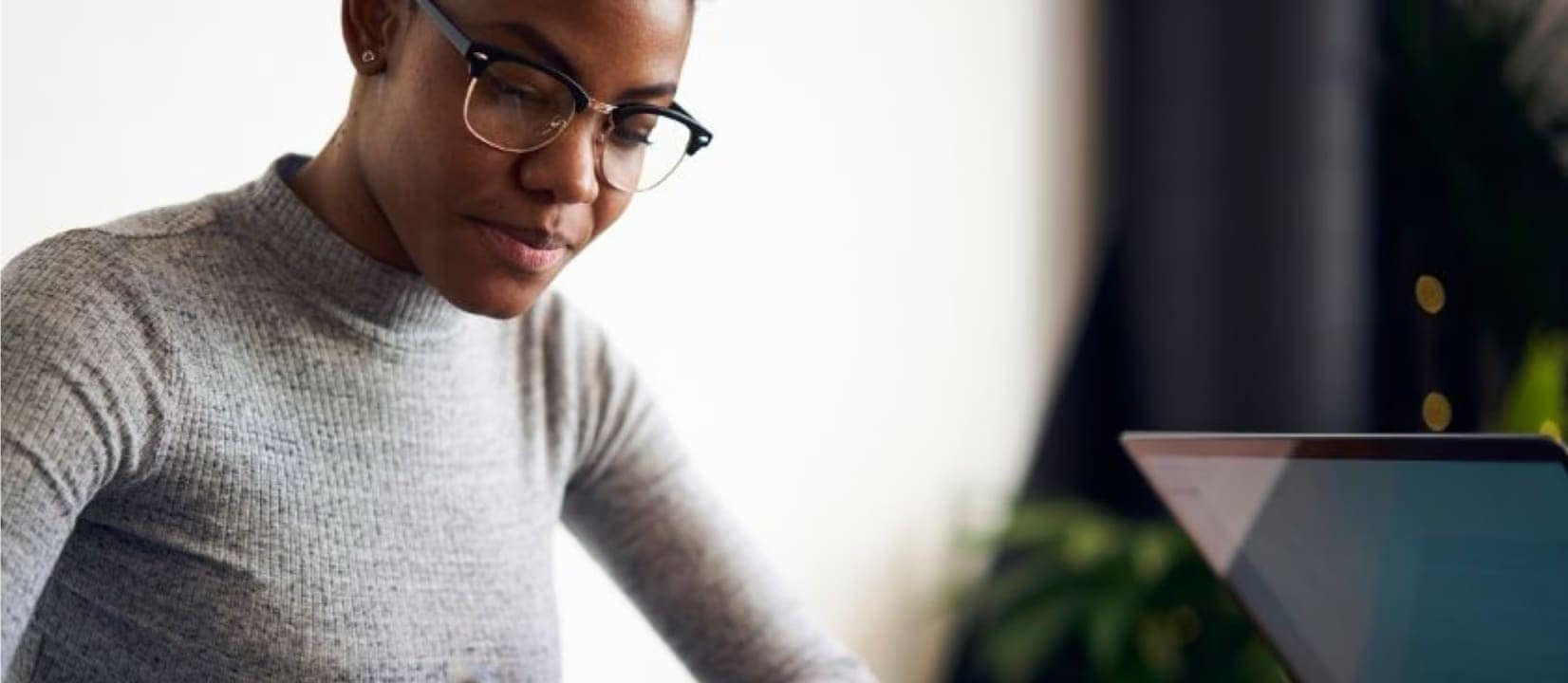 woman is sitting and writing on a paper