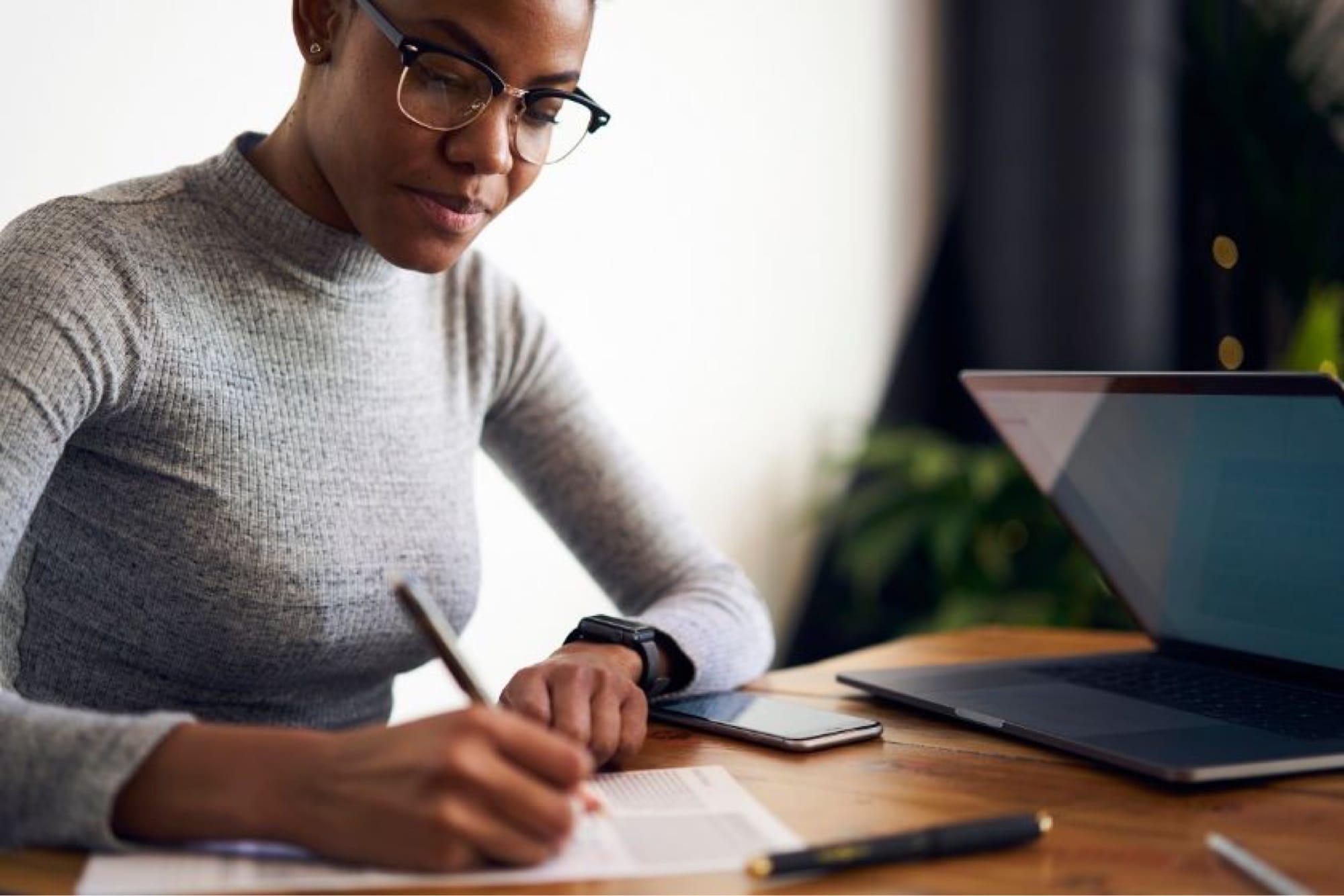 woman is sitting and writing on a paper