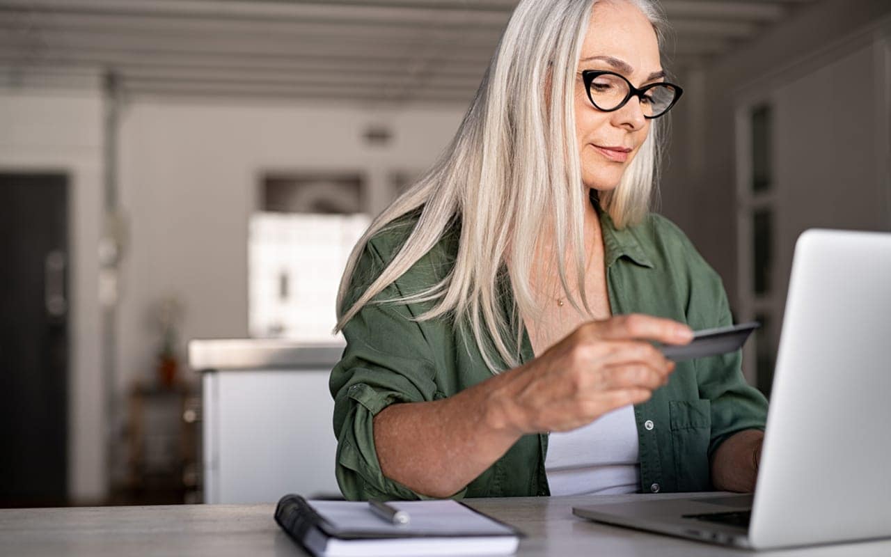 A professional image of a person reviewing their credit report on a laptop.
