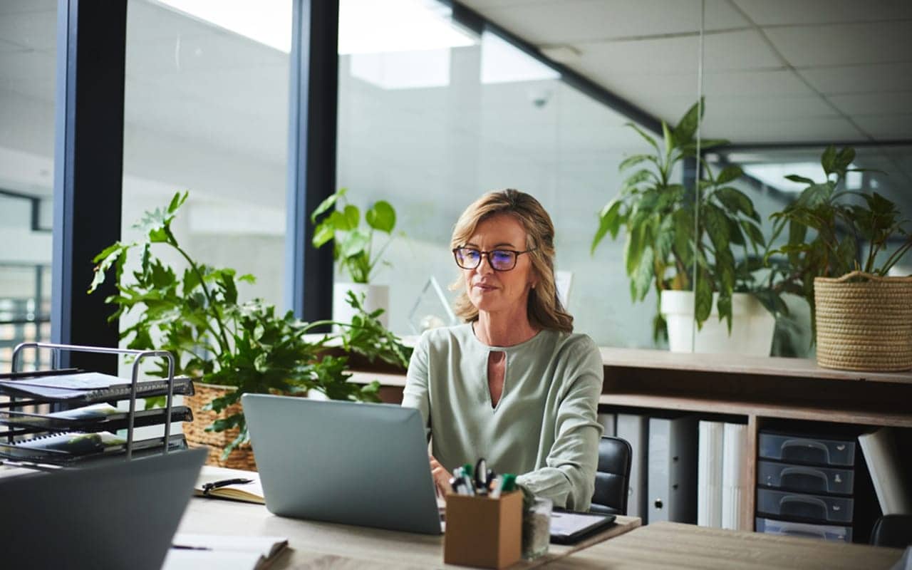 A professional image of a person reviewing their credit report on a laptop.