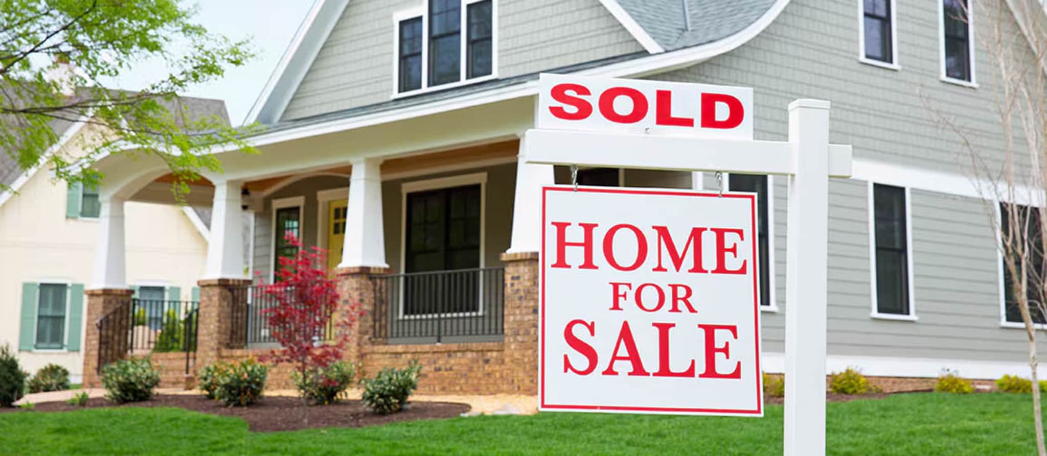 A sold sign prominently displayed in front of a house, symbolizing a successful real estate transaction involving earnest money.