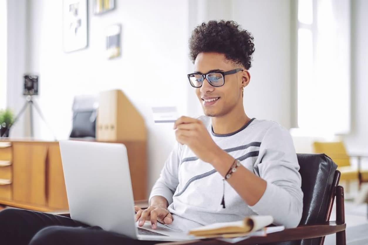 A man sits in a chair with his laptop in his lap