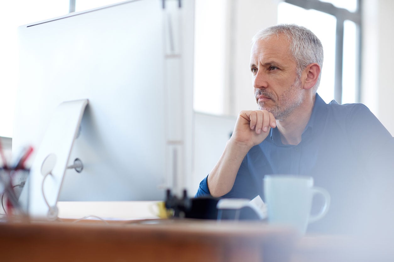 Man looks at his desktop monitor