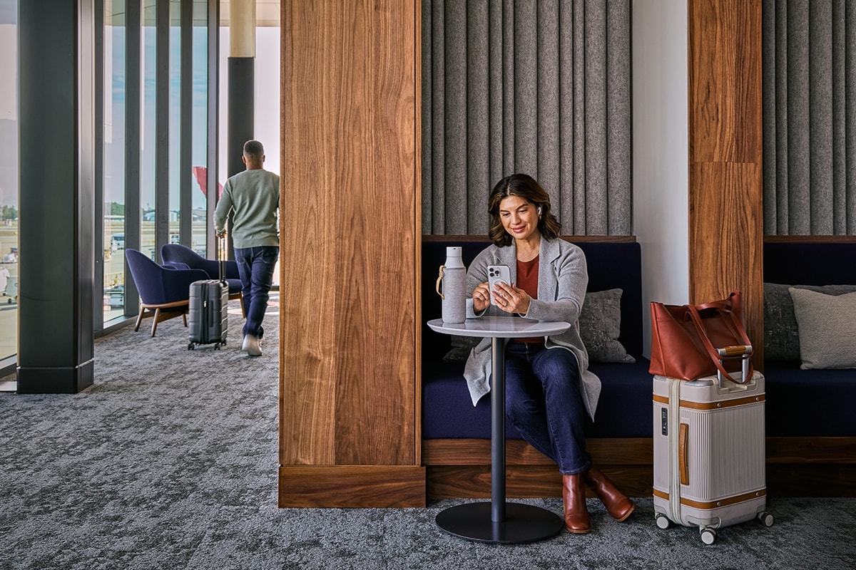 A traveler with luggage and coffee in a comfortable airport lounge  