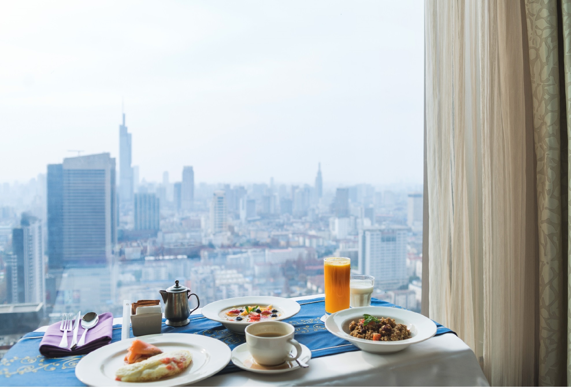 Cityscape view as seen from a skyscraper with breakfast in the foreground
