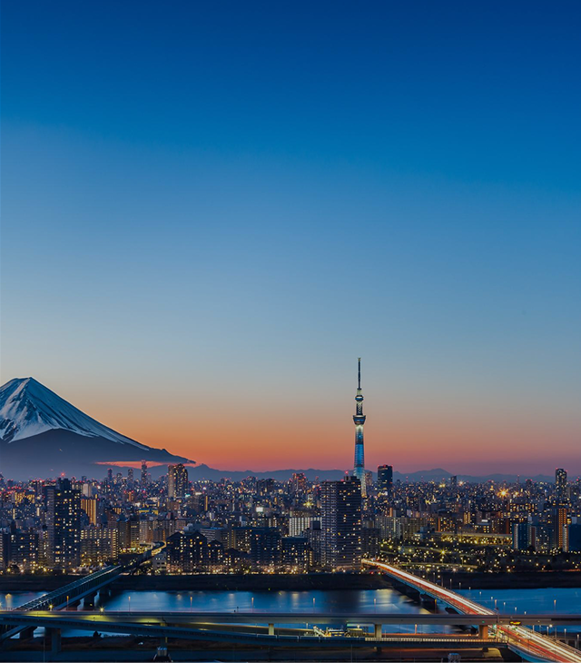 Vista panorámica nocturna de Tokio con el Monte Fuji y la Torre Tokyo Skytree iluminados al atardecer