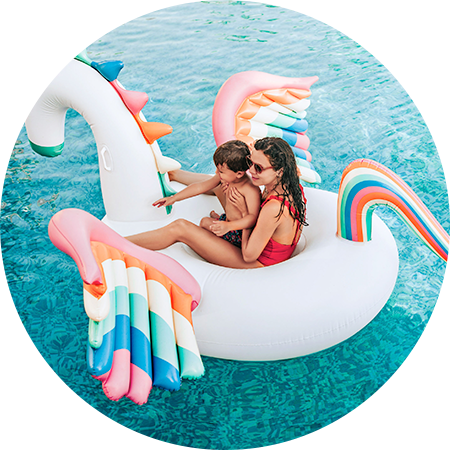 Una mujer y un niño se encuentran encima de un flotante en forma de pegaso en una alberca.
