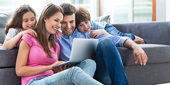 Familia usando una computadora para el Back to School con Meses sin Intereses de American Express
