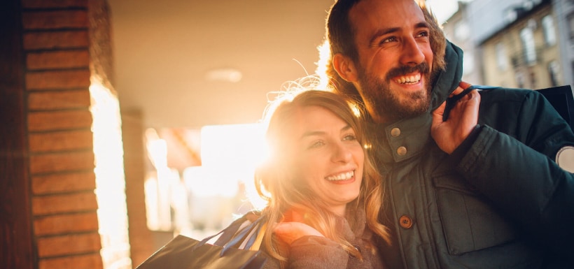 Una pareja sonriendo mientras hacen compras.
