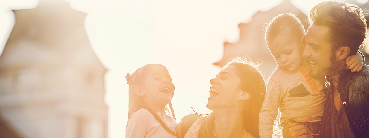 Una familia sonriendo de paseo por una ciudad.