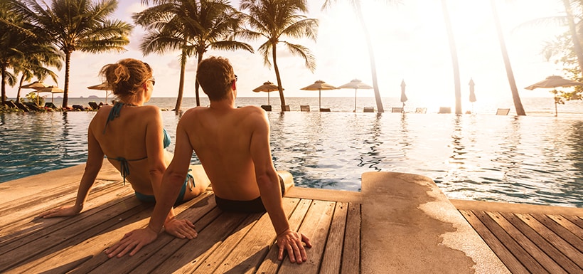 Una pareja junto a la alberca de un hotel.