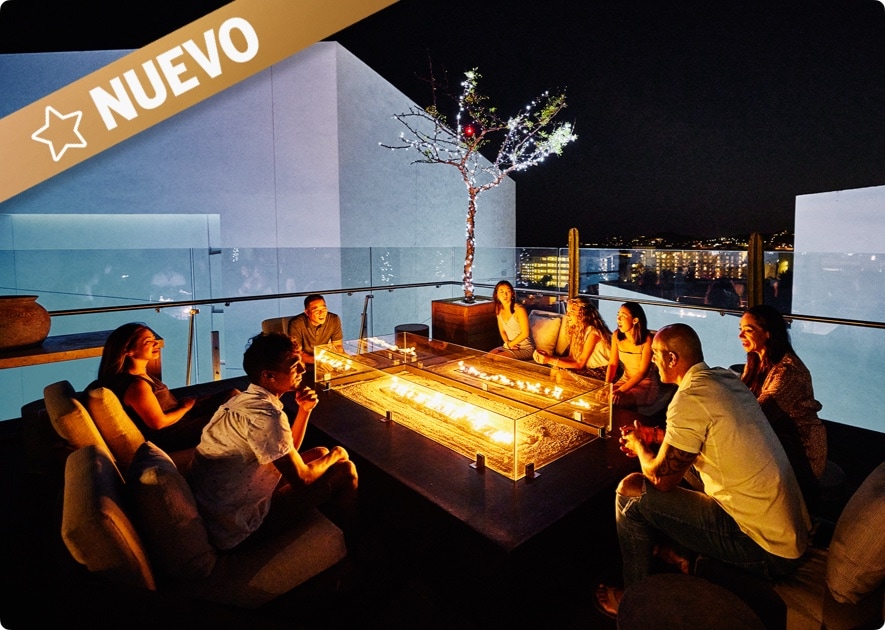 The Gold Card American Express: Mujer observando una vista nocturna desde un hotel.