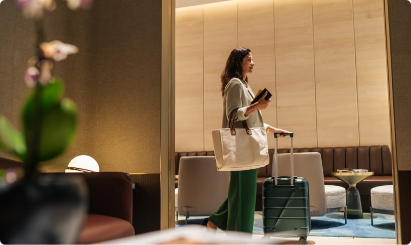 The Gold Card American Express: Mujer en una sala de aeropuerto, beneficio Priority Pass.