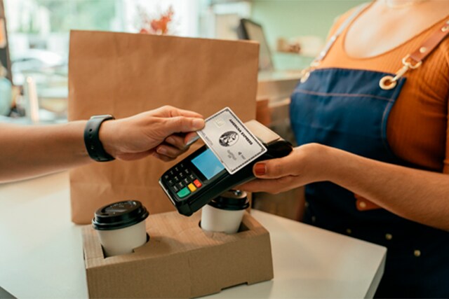 Cliente pagando con una Tarjeta American Express en un comercio