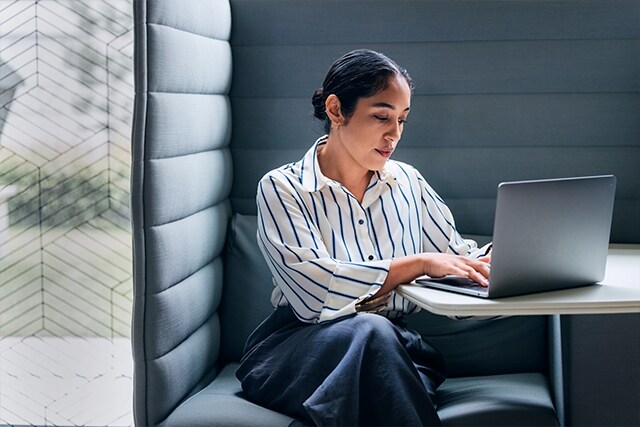 Mujer profesional trabajando en una computadora portátil en una zona tranquila de su oficina.